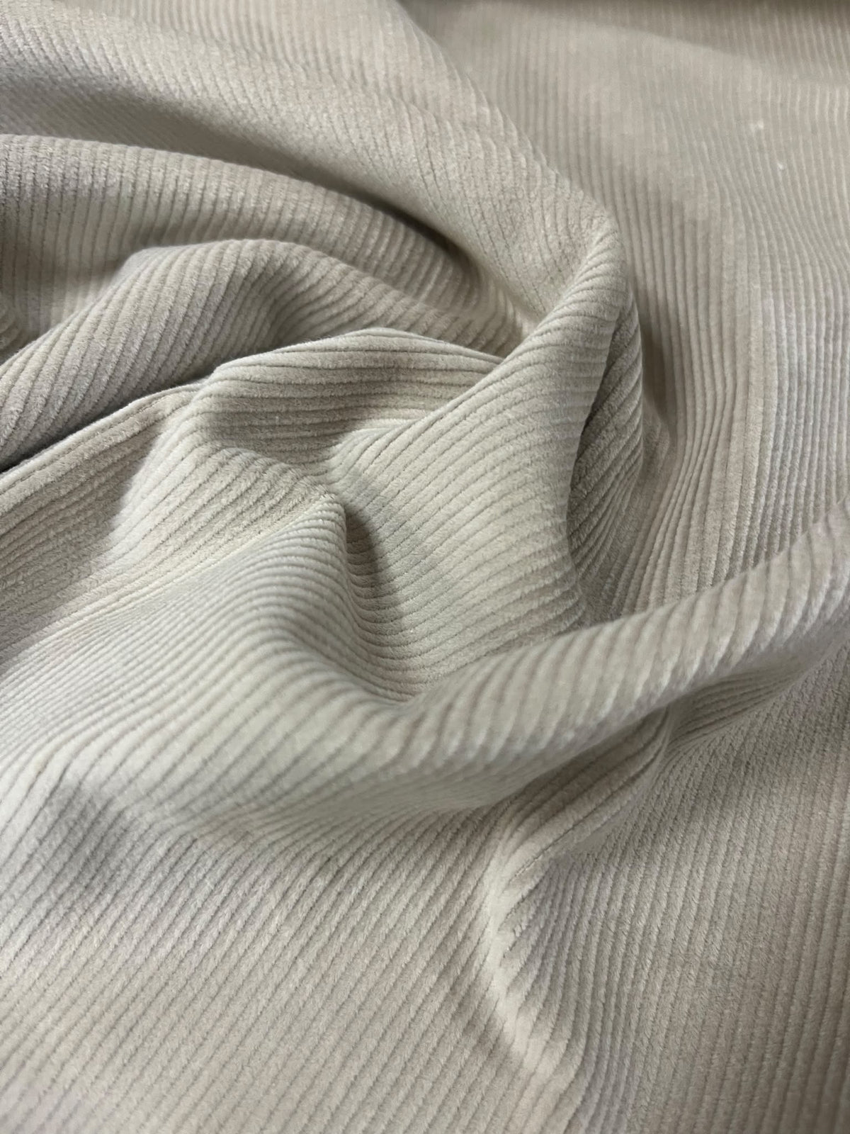 Tela de pana beige con pliegues y canales finos