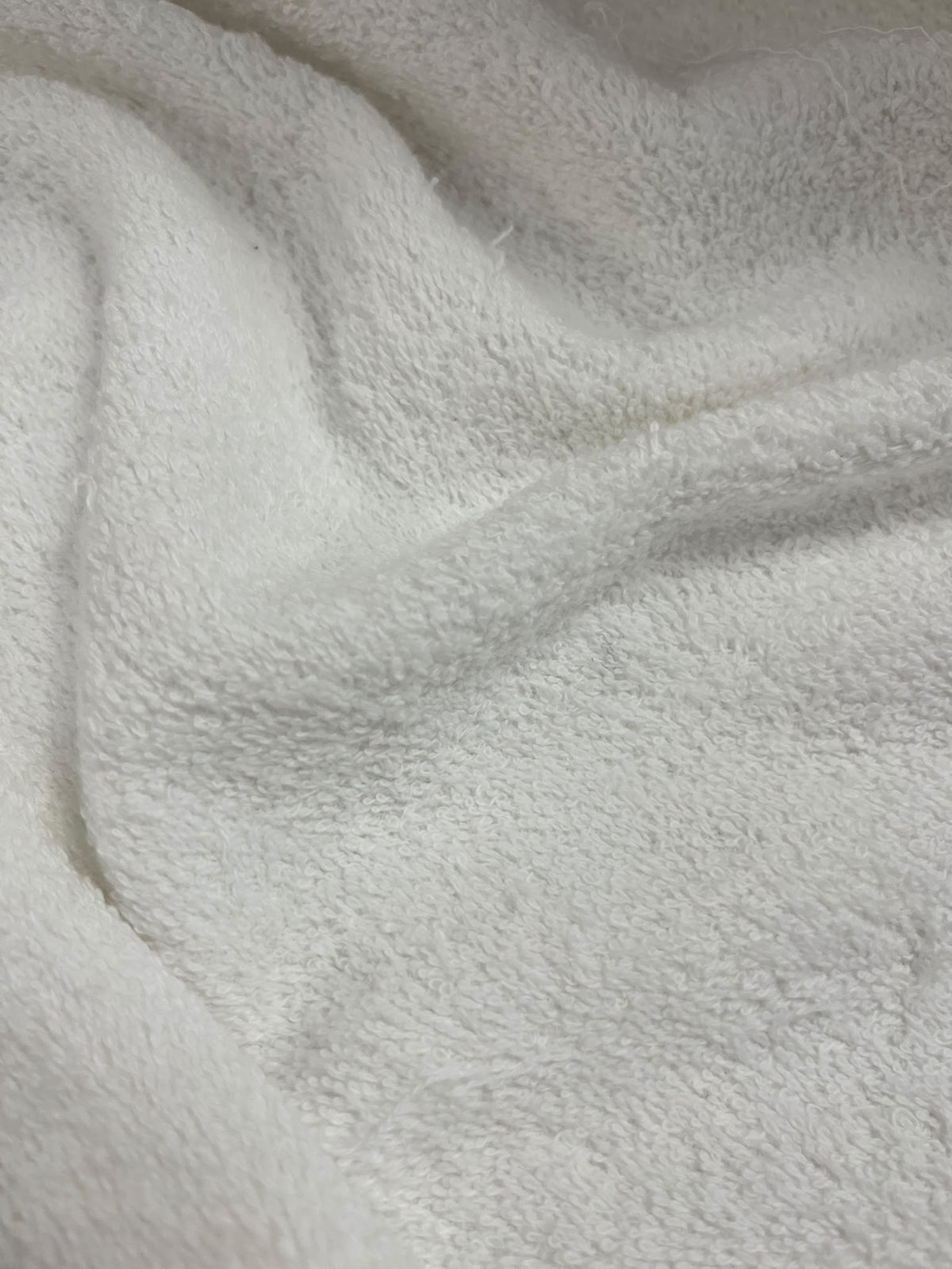 Tela de rizo blanco con pliegues y detalle de su textura de bucles